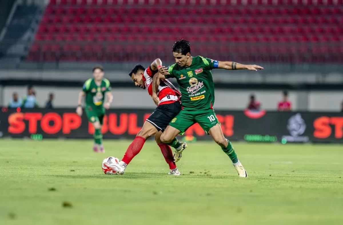 Striker Persebaya Bruno Moreira diadang pemain Madura United di laga pekan ke-16 Super League 2025/26  (Persebaya)