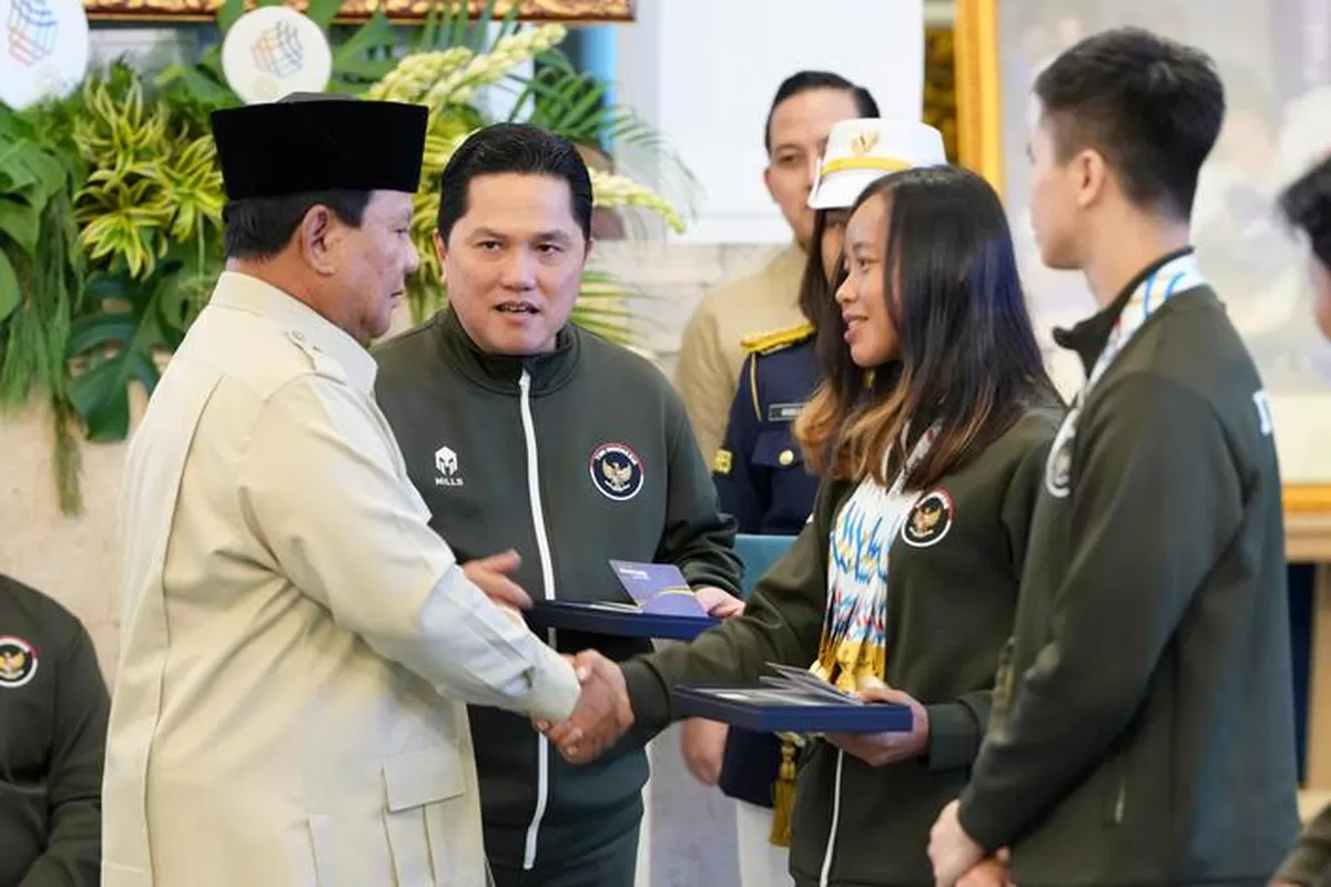 Presiden RI Prabowo Subianto, didampingi Menpora Erick Thohir, menyerahkan bonus SEA Games 2026, kepada perwakilan atlet triathlon putri, Martina Ayu Pratiwi di Istana Negara, 8 Januari 2026. (Sekretariat Presiden)