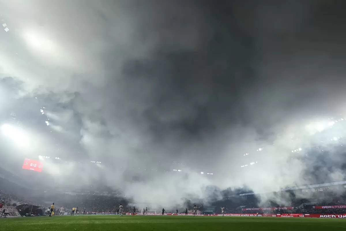 Kembang api sebelum pertandingan mengurangi jarak pandang di lapangan pertandingan antara Bayern Munich dan Cologne.