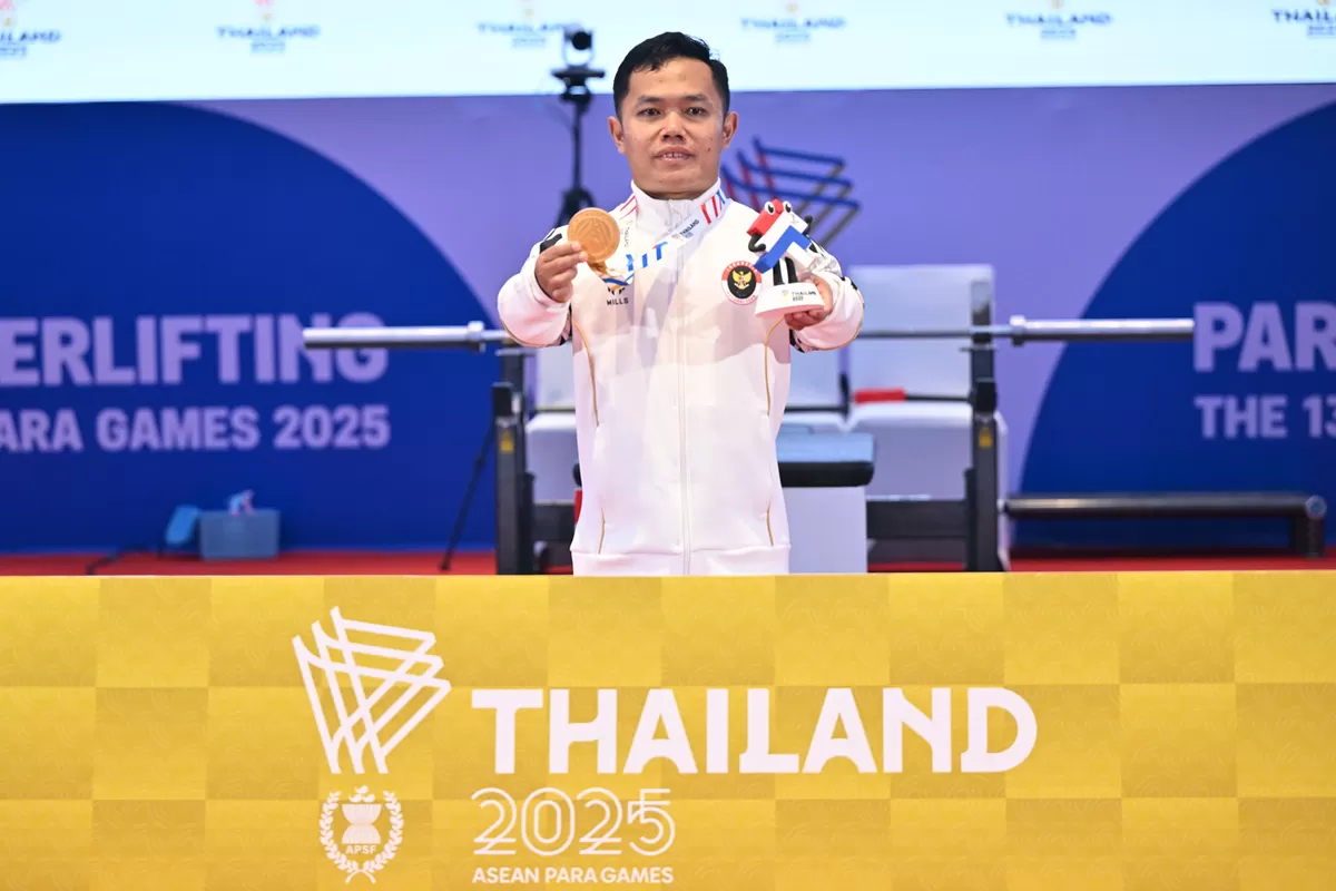 Atlet NPC Indonesia Hilman berpose dengan medali emas yang diraih dari cabang olahraga para angkat berat nomor 54kg putra ASEAN Para Games 2025 di Hall Terminal21, Nakhon Ratchasima, Thailand, Kamis (22/1/2026).  (Agung Wahyudi)