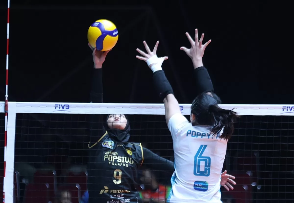 Pemain Jakarta Electric PLN Mobile, Poppy berusaha menahan smes dari pemain Popsivo Polwan pada laga terakhir mereka di putaran pertama Proliga 2026, Jumat, 30 Januari 2026 di Gresik. (PBVSI)