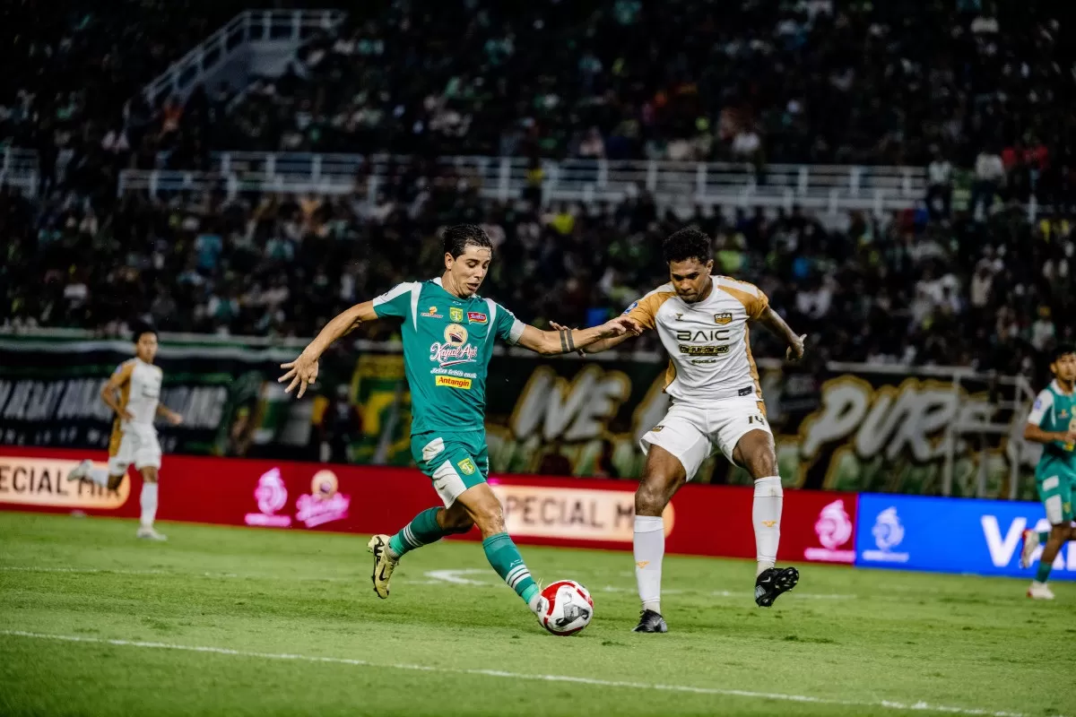 Penyerang Persebaya Bruno Moreira (kiri) berduel dengan pemain Dewa United Banten FC (Persebaya)