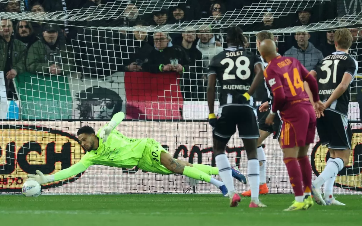 Maduka Okoye dari Udinese melakukan penyelamatan terhadap tembakan dari Donyell Malen dari Roma.