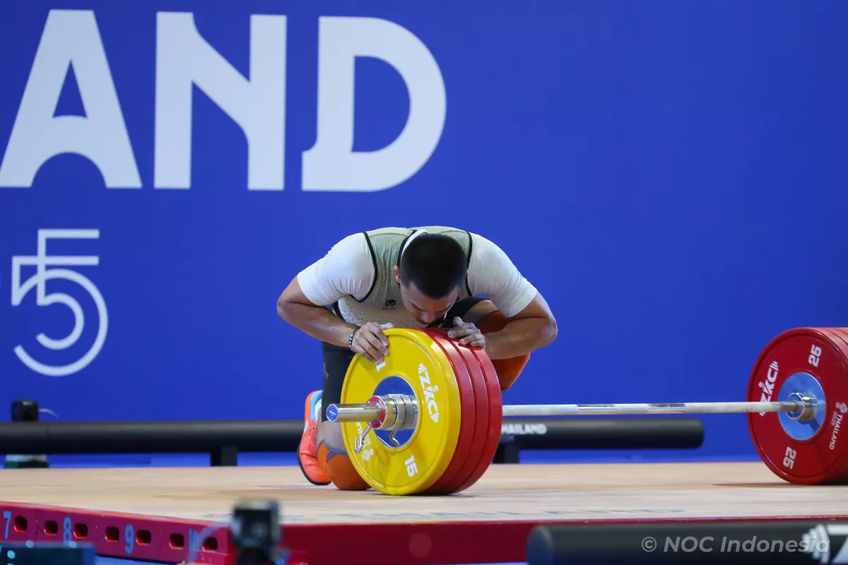 Final angkat besi kelas 79kg SEA Games 2025, Rizki Juniansyah mencium besinya usai dipastikan emas di Chonburi Sports School, Thailand. (Tetuko Mediantoro)