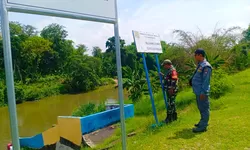 Antisipasi Banjir, Babinsa Joyotakan Patroli Cek Debit Pintu Air Plalan