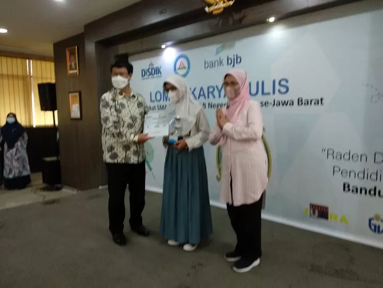 Dede Sisca Apriliani, siswi SMK Negeri 1 Tasikmalaya dan guru pembimbingnya  Lilis Julaeha saat menerima hadiah