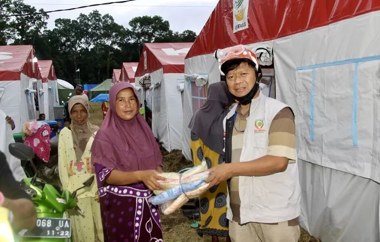 Secara simbolis ustaz Budiman menyerahkan bantuan mukena diposko 2 pengungsian - Foto: Henry Lukmanul Hakim