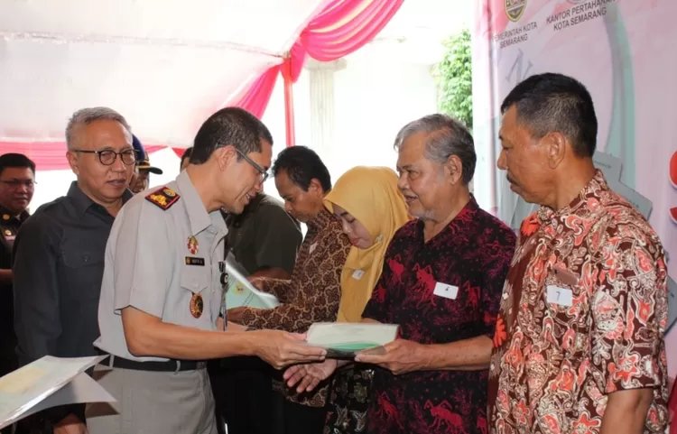 Kepala Kantor Pertanahan Kota Semarang Sigit Rachmawan Adhi menyerahkan sertipikat tanah Hak Milik (HM) dalam Program PTSL kepada masyarakat Kota Semarang 
