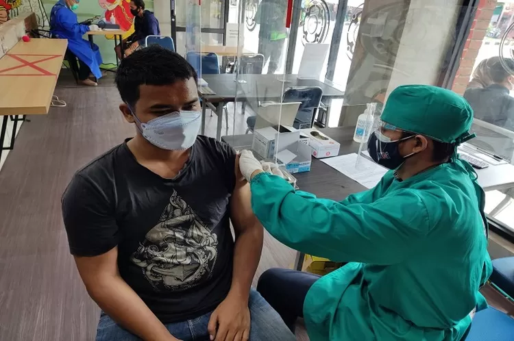 Seorang penumpang kereta api menerima vaksin Covid 19 yang dibuka PT KAI Daop 3 Cirebon di Klinik Mediska Cirebon. Selain vaksinasi, disediakan pula layanan rapid test antigen di Stasiun Cirebon.