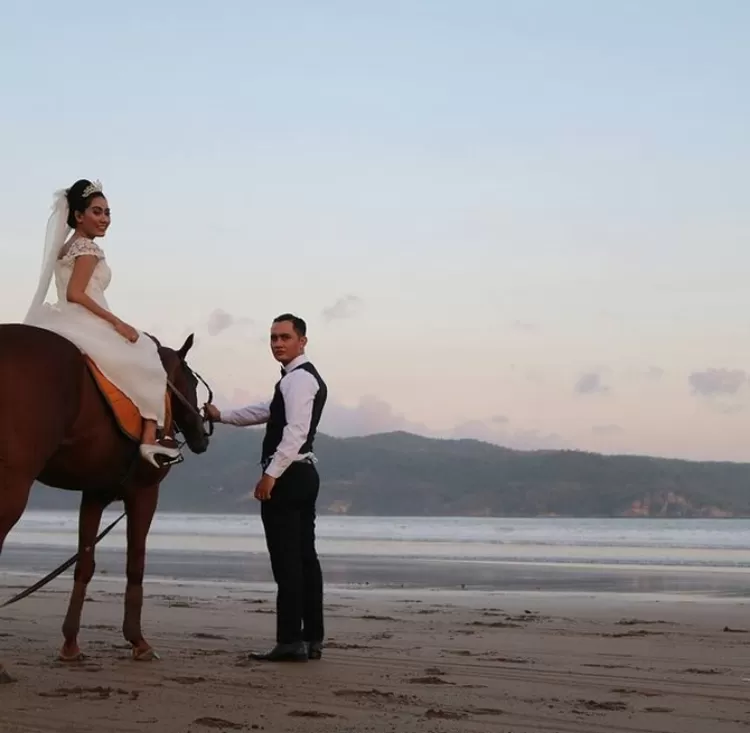  Berkuda bersama pasangan dalam momen sunset on the beach at Pantai Teleng Ria Pacitan wedding party