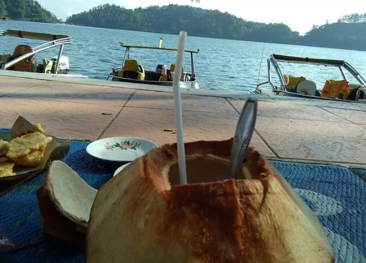 Spot foto di Telaga Ngebel terbaik, salah satunya adalah minum kelapa muda di tepi telaga 