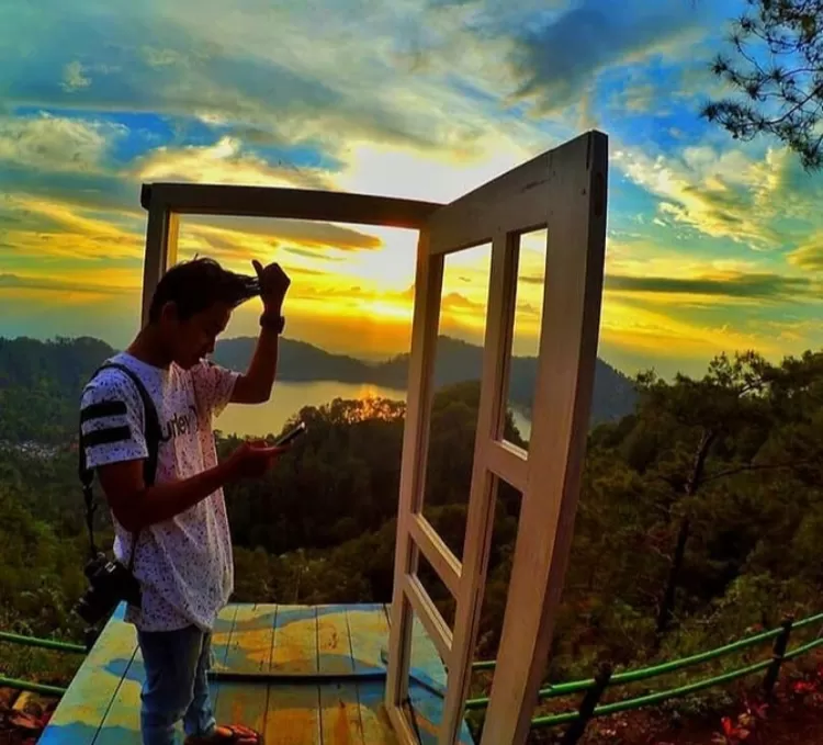 Salah satu pose di spot pintu aesthetic view Telaga Ngebel di destinasi wisata alam Mloko Sewu Ponorogo adalah candid di depan pintu aesthetic