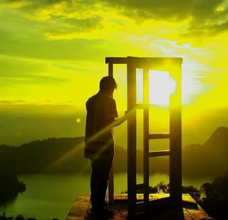 Salah satu pose di spot pintu aesthetic view Telaga Ngebel di destinasi wisata alam Mloko Sewu Ponorogo adalah di antara pintu kala sunset yang fenomenal