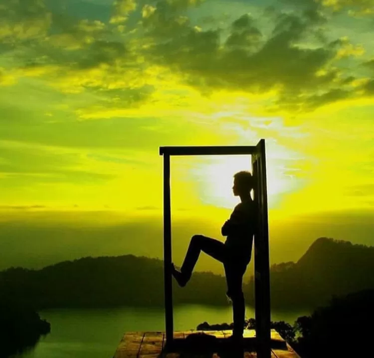 Salah satu pose di spot pintu aesthetic view Telaga Ngebel di destinasi wisata alam Mloko Sewu Ponorogo adalah tepat ditengah pintu aesthetic kala sunset yang fenomenal