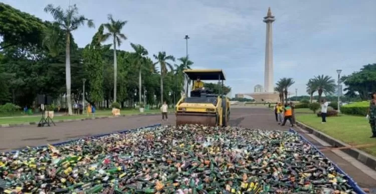 Pemusnahan minuman beralkohol ilegal dilakukan dengan menggunakan alat berat.