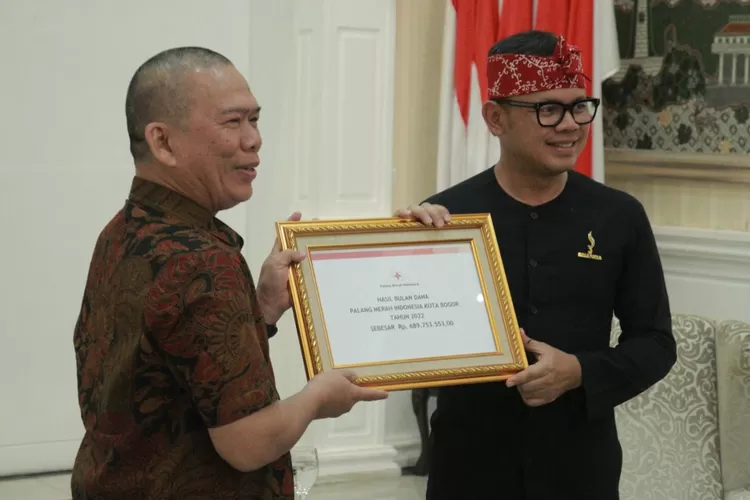 Ketua PMI Kota Bogor, Edgar Suratman (kiri) menyerahkan laporan kepada Wali Kota Bogor, Bima Arya