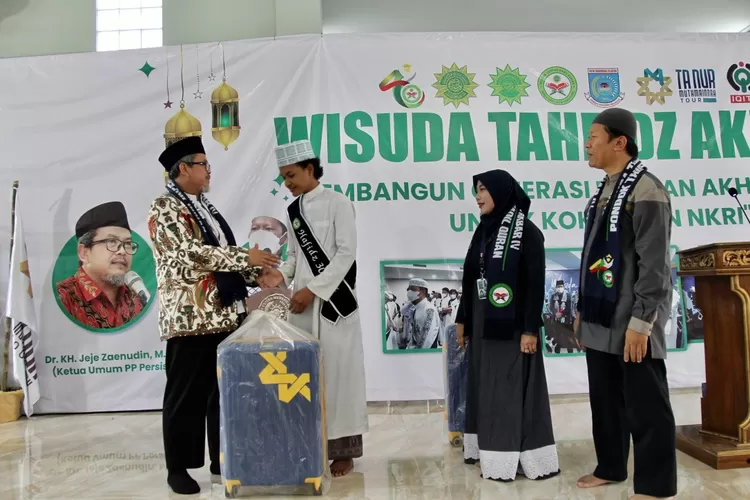 Ketua Umum PP PERSIS Ustaz Jeje Zaenudin secara simbolik memberikan koper umroh dengan didampingi Komisaris Ta Nur Muthmainnah Tour Fitri Heni dan Ketua PD PERSIS Kota Tangerang  Ustaz Budiman - Foto: Henry Lukmanul Hakim