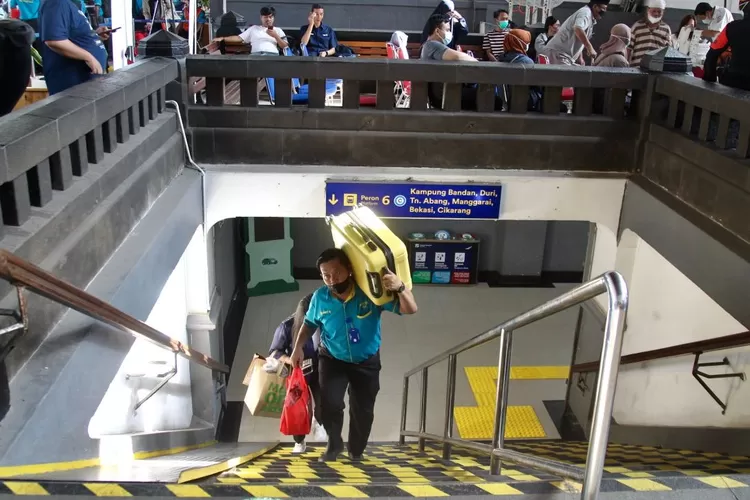 Porter sedang membantu membawakan barang penumpang Kereta Api  di Stasiun Pasar Senen - Foto: Henry Lukmanul Hakim