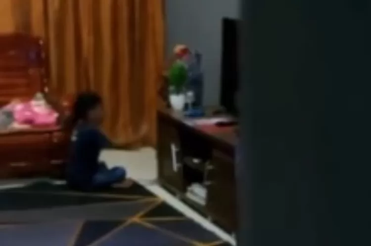 Cuplikan video seorang anak laki-laki main dengan sosok tak kasat mata.