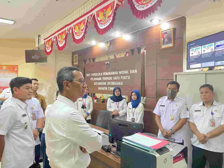 Penjabat Gubernur DKI Jakarta Heru Budi Hartono memperhatikan  penjelasan alur pelayanan publik di PTSP Kecamatan Jatinegara, Rabu (7/6/2023)