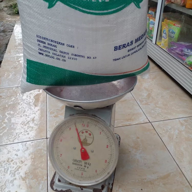 Warga Desa Cinangka menimbang beras yang diterima hanya sekitar 9 kilogram