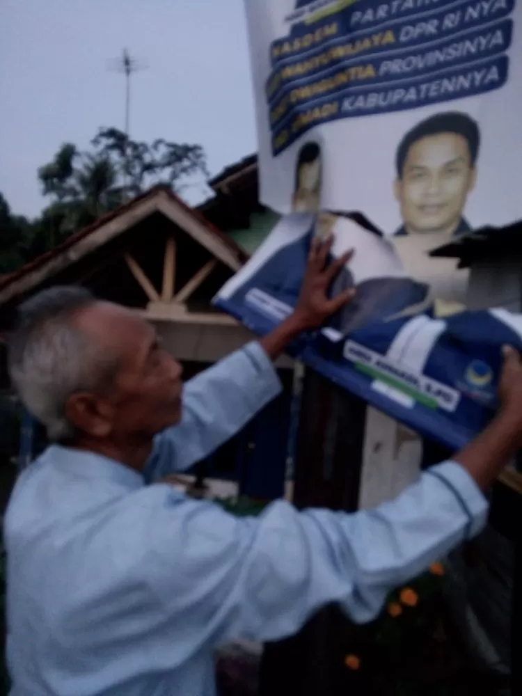 Warga memperlihatkan gambar Andi Ahmadi bacaleg Daerah Pemilihan 5 (Dapil 5) Kabupaten Bogor yang telah dirusak OTK..