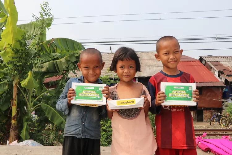 Anak- anak bantaran kali  menerima paket  makanan siap  santap dari Baznas  Bazis  DKI Jakarta- Maybank Indonesia. 