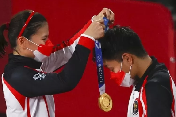 Greysia Polii mengalungkan medali emas kepada Apriyani Rahayu di Olimpiade Tokyo 2020. (Foto/Reuters)