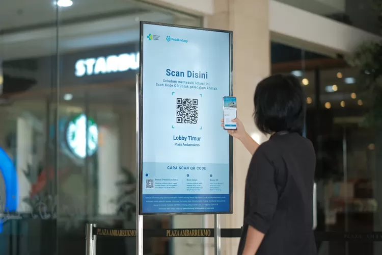 Pengunjung melakukan scan QR code menggunakan aplikasi PeduliLindungi sebelum memasuki mal di Sleman.  (Istimewa)