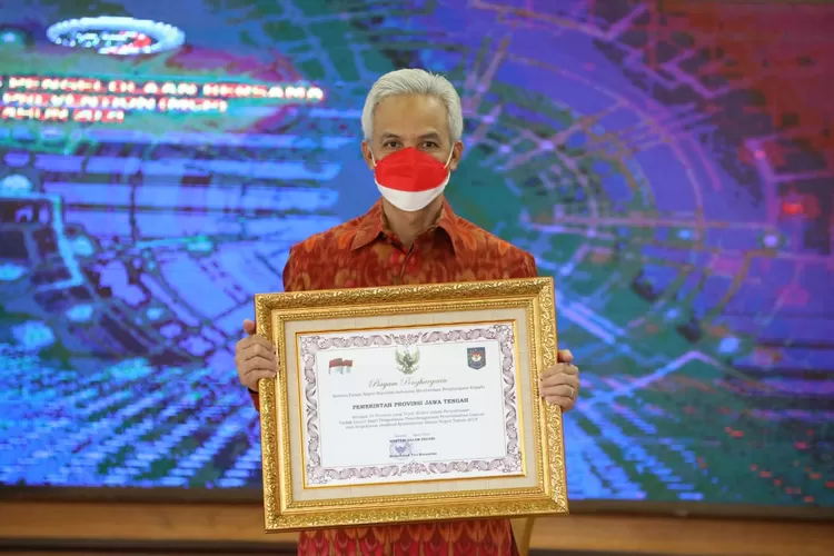 Gubernur Jateng, Ganjar Pranowo, menunjukkan piagam penghargaan TLHP dari Kemendagri, Selasa (31/8/2021).