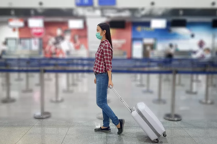 Asian tourist with luggage ,wearing mask to prevent during travel time at the airport terminal for protect from the new Coronavirus 2019 infection outbreak situation (asiandelight)