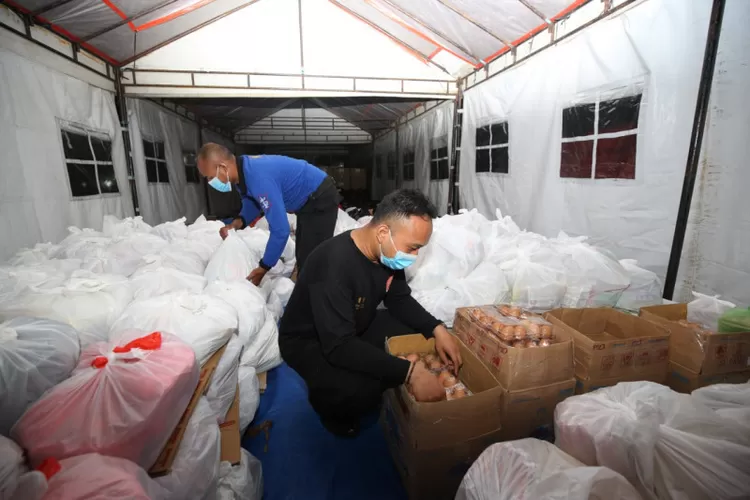 Dua petugas Pemkot Surabaya sedang menata bantuan sosial (banso) di Posko Surabaya Peduli yang ada di halaman Balai Kota Surabaya.  (ANTARA/HO-Humas Pemkot Surabaya)
