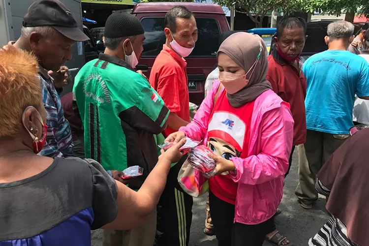 Selain nasi kotak, karyawan JNE dan Polsek Umbulharjo membagikan masker kain untuk warga terdampak pandemi.   (Dokumen JNE)