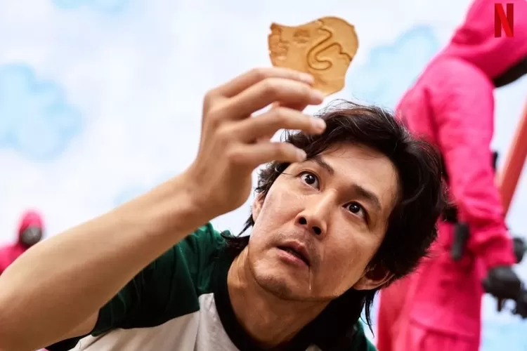 Gi Hun (Lee Jung Jae) yang sedang memegang permen dalgona dengan pola payung dalam episode 3 drama seris Netflix 'Squid Game'. (Imstagram/@netflixkr)