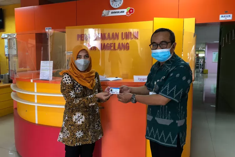 Seorang pengunjung menerima kartu anggota perputakaan Kota Magelang.  (Foto: Dokumentasi Disperpusip Kota Magelang)