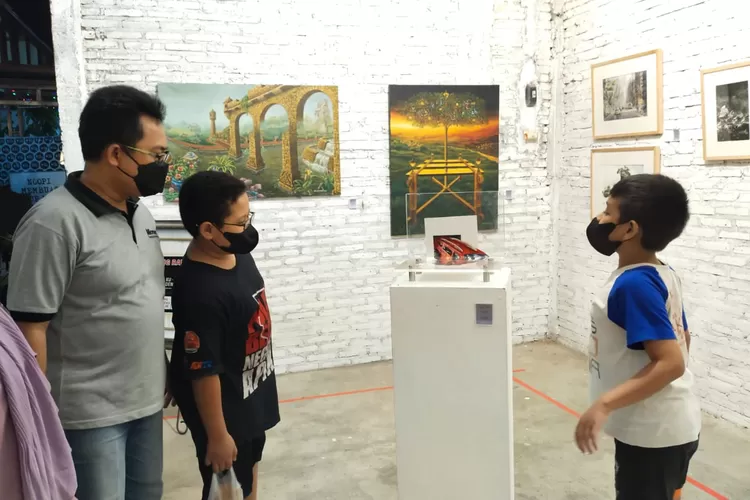 Pengunjung pameran tunggal Deni Junaedi, keluarga Muhammad Syafii melihat lukisan unik di Kopikuden. ( Dok DINI Art Manajemen)