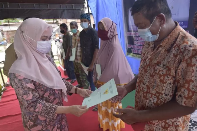 Bupati Luwu Utara menyerahkan sertifikat kepada warga Desa Sepakat (Humas Pemkab Luwu Utara)