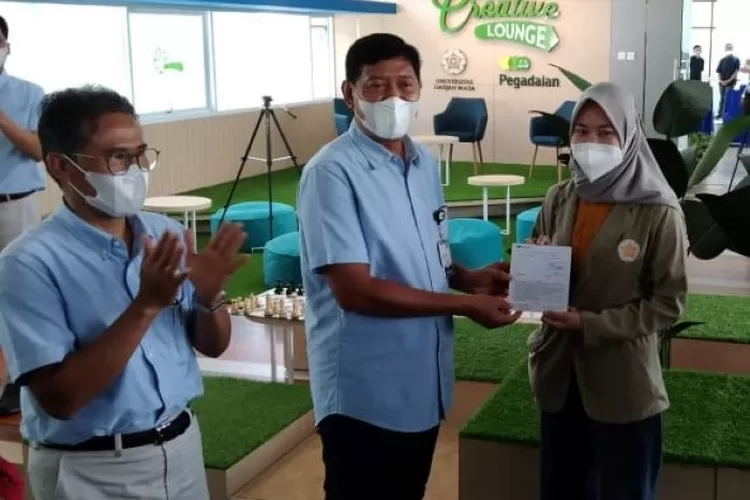  Dirut Pegadaian, Kuswiyoto, menyerahkan beasiswa kepada mahasiswa UGM di sela peresmian The Gade Creative Lounge di lantai 4 Perpustakaan Pusat UGM, Yogyakarta, Selasa 7 Desember 2021. (dok Pegadaian)