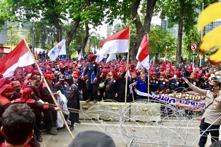 Massa buruh dengan menggunakan rantai mengkoyak-koyak kawat berduri, mereka ingin berorasi didepan Gedung Mahkamah Konstitusi - Foto: Henry Lukmanul Hakim