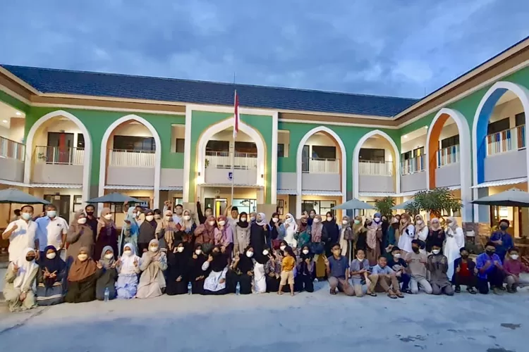Orang tua, murid dan staf Yayasan PCI berfoto bersama dengan latar belakang SMP PCI - Foto: Dokumen PCI