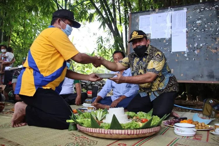 Wakil Bupati Kendal Windu Suko Basuki menerima potongan tumpeng tanda pembangunan pagar makam Desa Ngasinan Weleri. (edi prayitno/ kontributor Kendal)