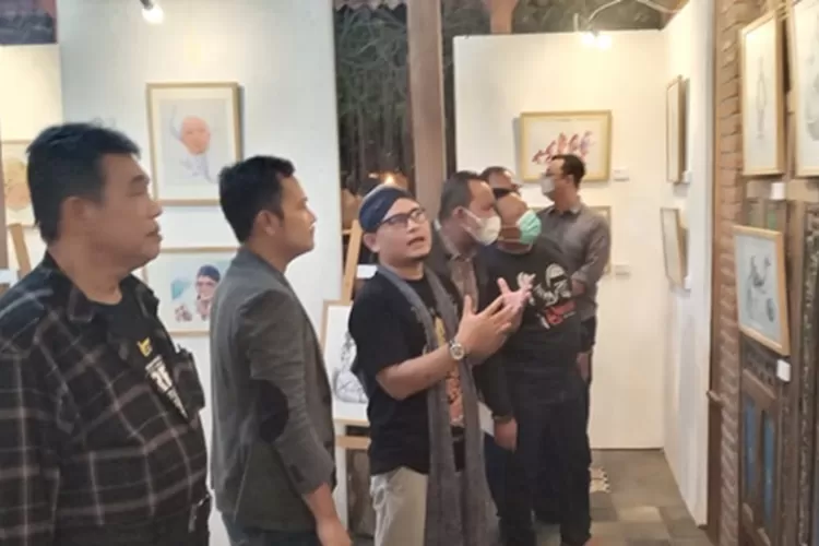 Dosen Ilmu Seni dan Arsitektur IAIN Walisongo Semarang Abdullah Ibnu Talhah menjelaskan lukisan hasil karyanya kepada sejumlah pengunjung.  (dok)