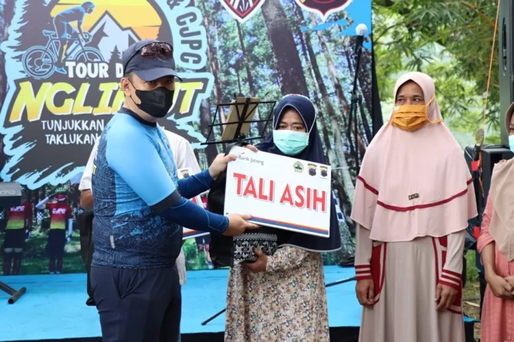 Kapolres Kendal AKBP Yuniar Ariefianto menyerahkan tali asih kepada pelaku UMKM disela acara Tour de Nglimut, Sabtu 8 januari 2022.  (edi prayitno/kontributor Kendal)