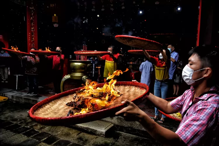 Salah seorang umat Tri Dharma Tay Kak Sie sedang membakar kertas doa dalam rangka ritual Pek Kong Naik. Ritual ini rutin digelar jelang Imlek tiap tahun. (Ayosemarang.com/ Audrian Firhannusa)