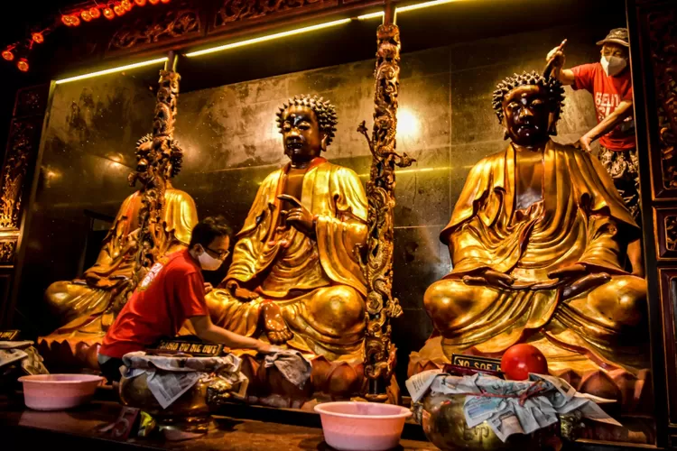 Petugas Kelenteng Tay Kak Sie sedang membersihkan patung Dewa-Dewi. Tradisi bersih-bersih ini dilakukan setelah prosesi Pek Kong Naik atau saat Dewa-Dewi naik ke langit. (Ayosemarang.com/ Audrian Firhannusa)