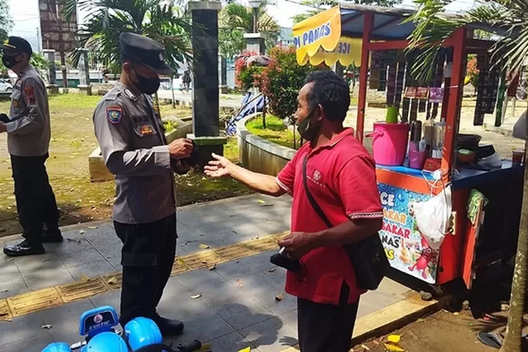 Petugas Polsek Sukorejo membagikan masker di kawasan Bunderan Sukorejo, Rabu 2 januari 2022.  (edi prayitno/kontributor Kendal)