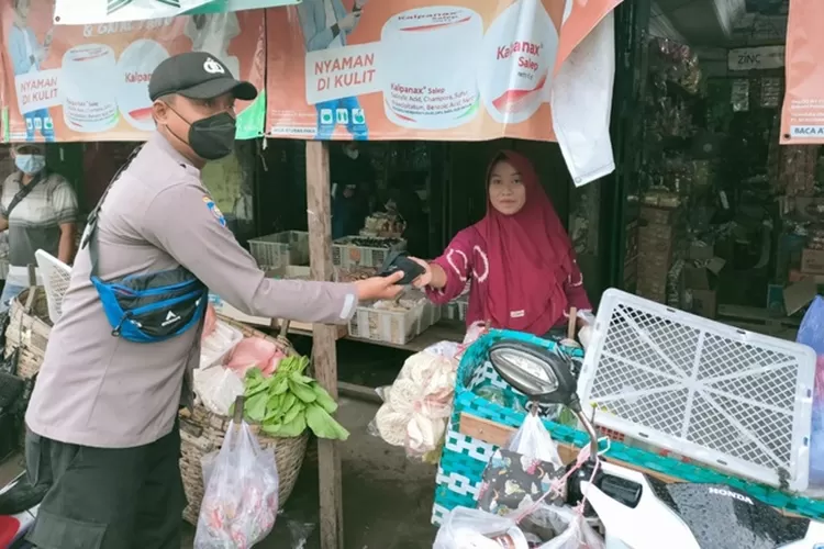 Anggota Polsek Cepiring membagikan masker kepada warga yang ada di Pasar Cepiring, Sabtu 19 februari 2022.  (edi prayitno/kontributor Kendal)