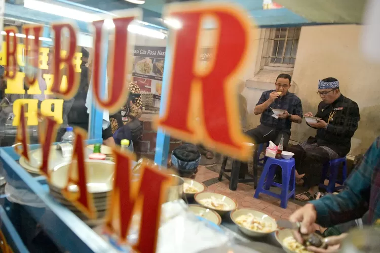 Gubernur Jawa Barat M Ridwan Kamil beraama Gubernur DKI Jakarta Anies Baswedan menikmati bubur ayam di jalan homan, Kota Bandung, Kamis (24/2/2022). (Foto: Rizal FS/Biro Adpim Jabar)