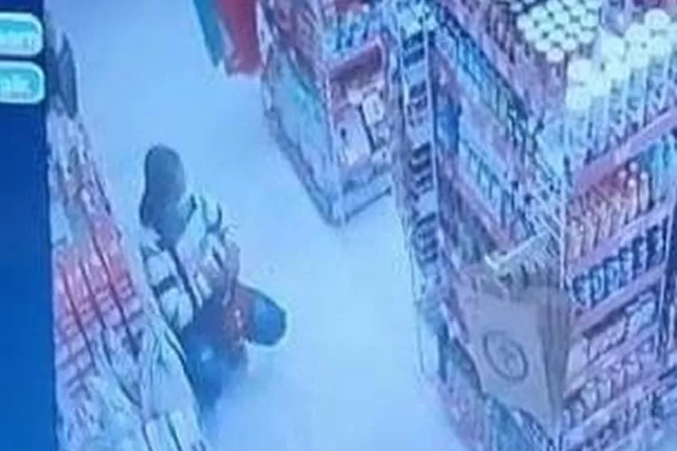  Pelaku pencurian minyak goreng saat memasukan hasil jarahannya ke dalam tas seperti terekam kamera CCTV. (tangkapan layar)