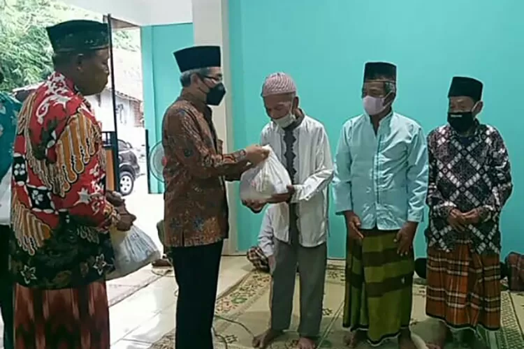 Bupati Bantul H Abdul Halim Muslih menyerahkan santunan kepada dhuafa.  (Dokumen)